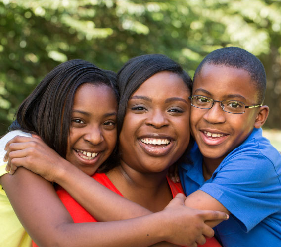 woman smiling flanked by smiling children